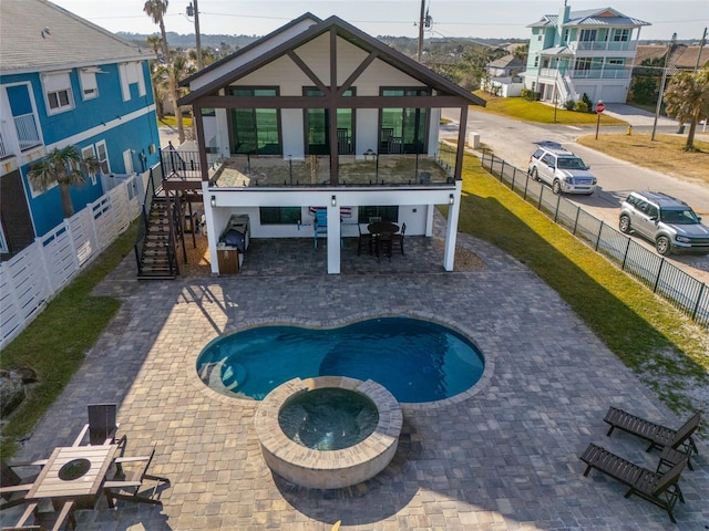 back of house featuring a patio area and an in ground hot tub