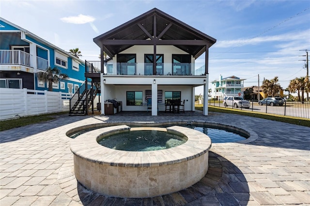 back of property with a pool with hot tub and a patio area