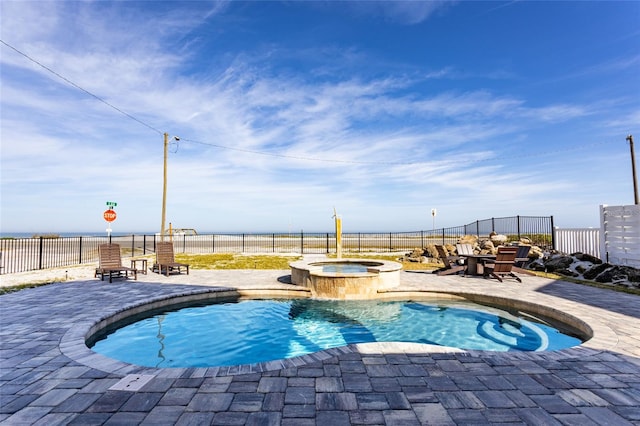 view of pool featuring a patio area, pool water feature, and an in ground hot tub