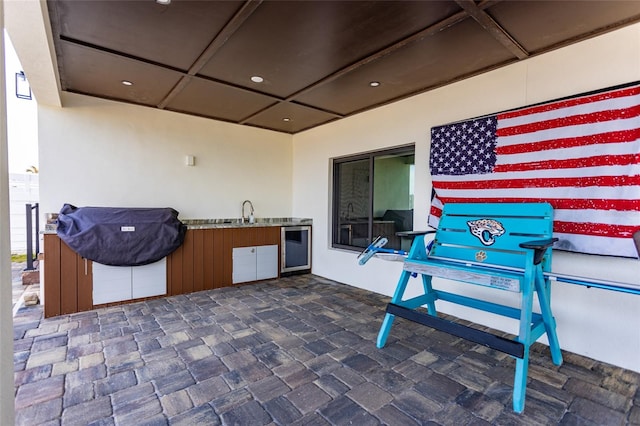 view of patio with wine cooler, exterior kitchen, and sink