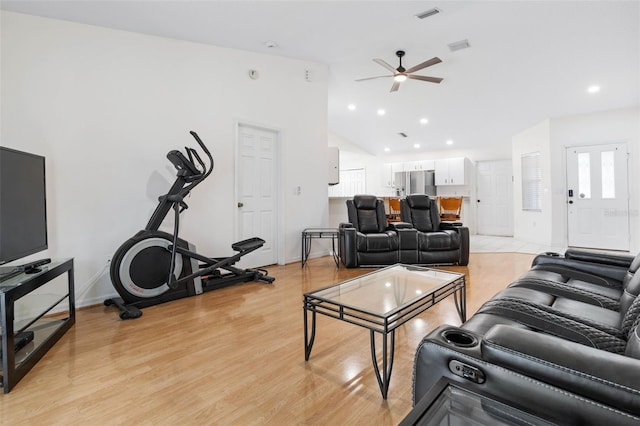 living room featuring ceiling fan, lofted ceiling, and light wood-type flooring