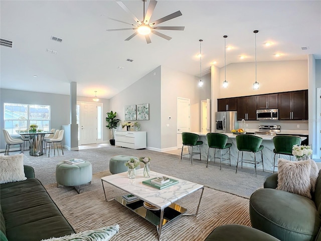 living room featuring light colored carpet and high vaulted ceiling