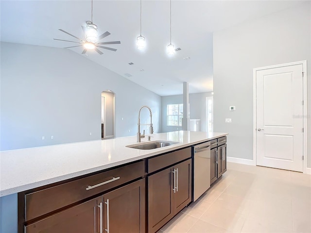 kitchen with sink, hanging light fixtures, stainless steel dishwasher, dark brown cabinetry, and light stone countertops