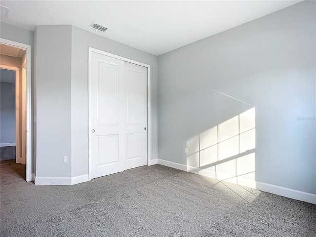 unfurnished bedroom with carpet flooring and a closet