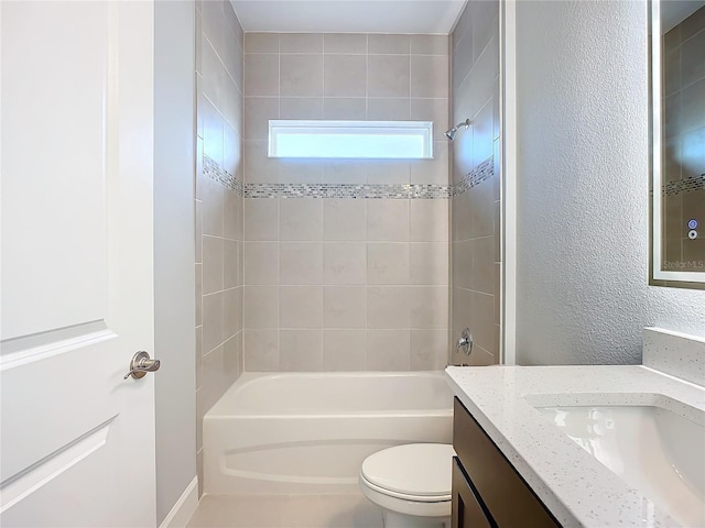 full bathroom featuring tiled shower / bath, vanity, and toilet