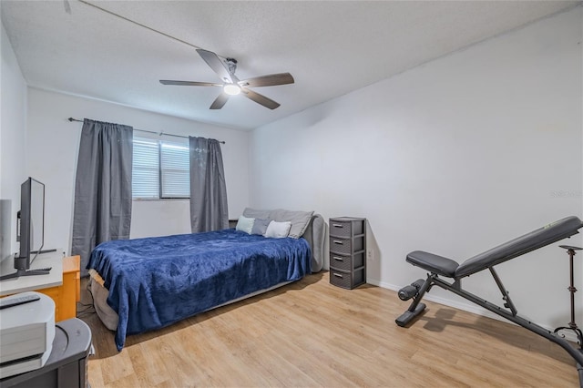 bedroom featuring hardwood / wood-style flooring, ceiling fan, and a textured ceiling