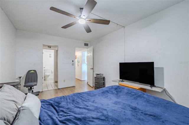 bedroom featuring ceiling fan, ensuite bath, and light hardwood / wood-style flooring