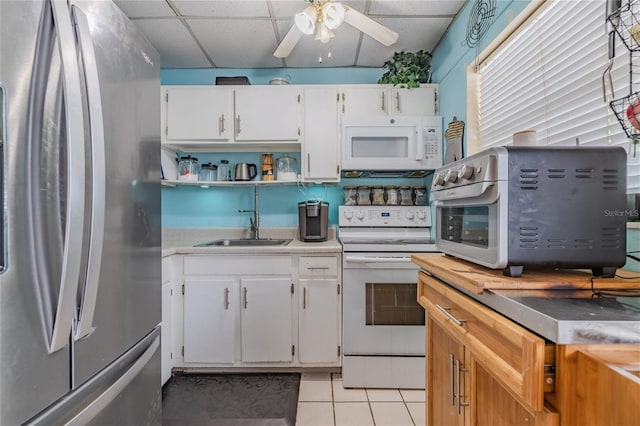 kitchen featuring open shelves, white appliances, a drop ceiling, light tile patterned flooring, and a ceiling fan