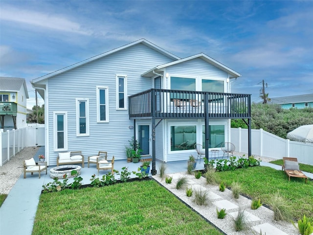 rear view of property with an outdoor fire pit, a lawn, a patio area, and a fenced backyard