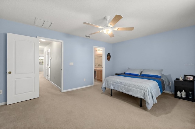 bedroom with light colored carpet, ceiling fan, and ensuite bathroom