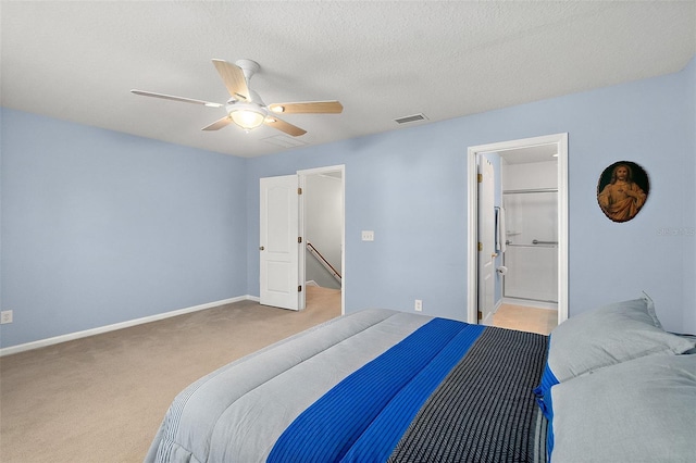 carpeted bedroom with ceiling fan and a textured ceiling