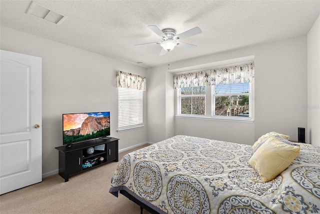 carpeted bedroom with ceiling fan and a textured ceiling