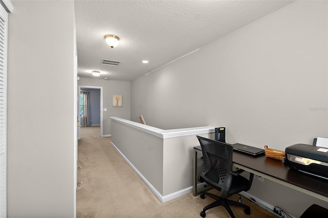 home office featuring light colored carpet and a textured ceiling