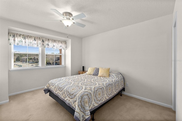 carpeted bedroom with ceiling fan and a textured ceiling