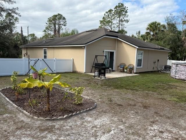 back of property featuring a yard and a patio