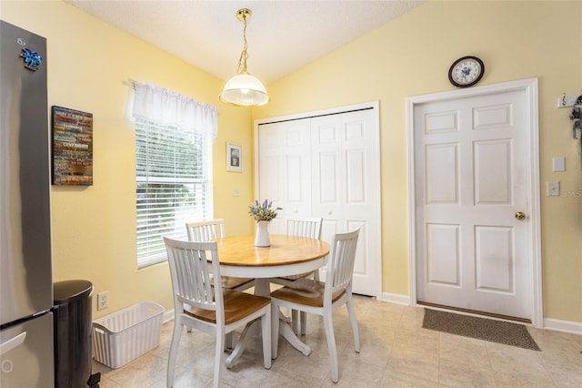 tiled dining room with vaulted ceiling