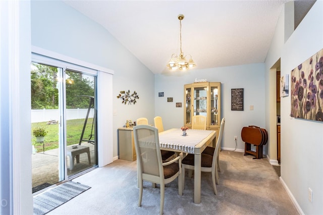 dining space with lofted ceiling, carpet floors, and a chandelier