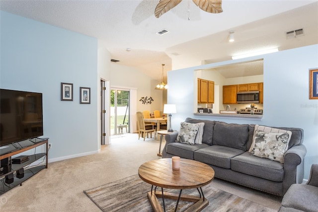 living room featuring light colored carpet, lofted ceiling, and ceiling fan with notable chandelier