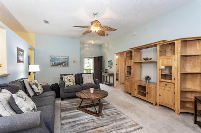 carpeted living room with ceiling fan, lofted ceiling, and a textured ceiling