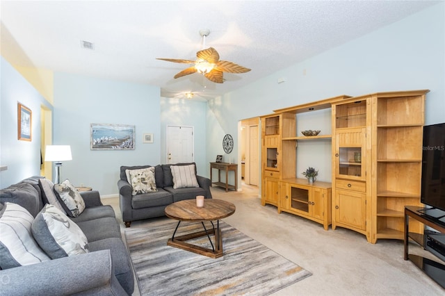 carpeted living room with lofted ceiling, a textured ceiling, and ceiling fan