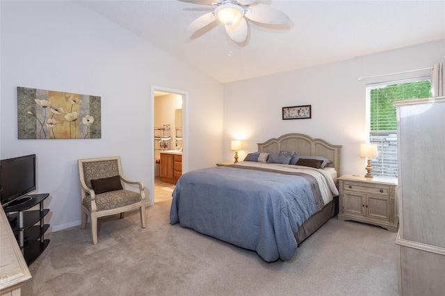 bedroom featuring light carpet, connected bathroom, lofted ceiling, and ceiling fan