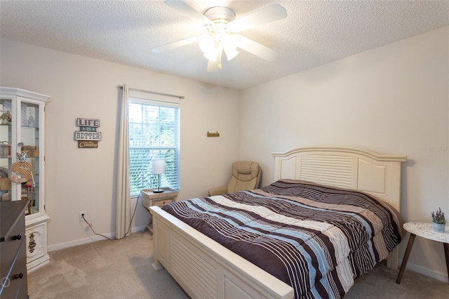 carpeted bedroom featuring ceiling fan and a textured ceiling