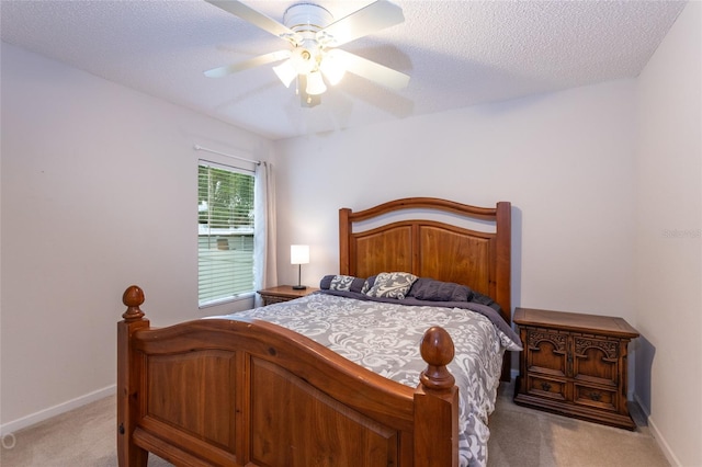 bedroom featuring ceiling fan, light carpet, and a textured ceiling