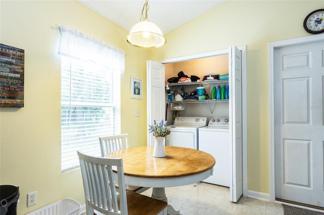 tiled dining space with vaulted ceiling and washer and dryer