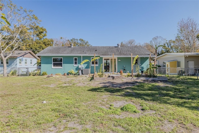 rear view of house with a yard and central AC