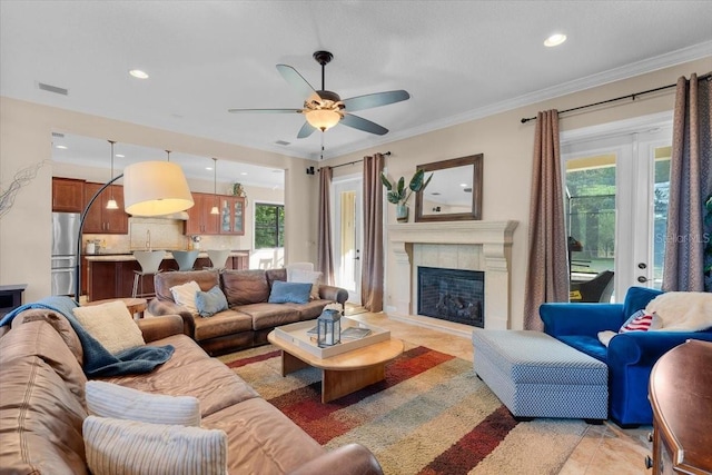 tiled living room with crown molding, a healthy amount of sunlight, and a premium fireplace