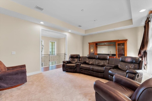 carpeted living room with a raised ceiling