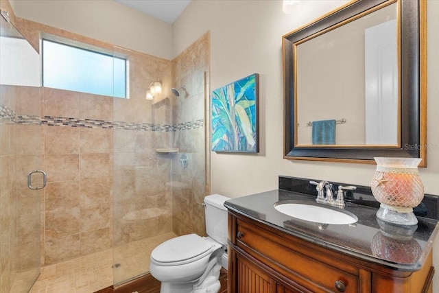 bathroom featuring vanity, toilet, and an enclosed shower