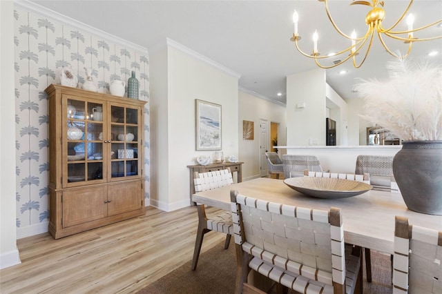 dining room with ornamental molding, a notable chandelier, and light hardwood / wood-style floors