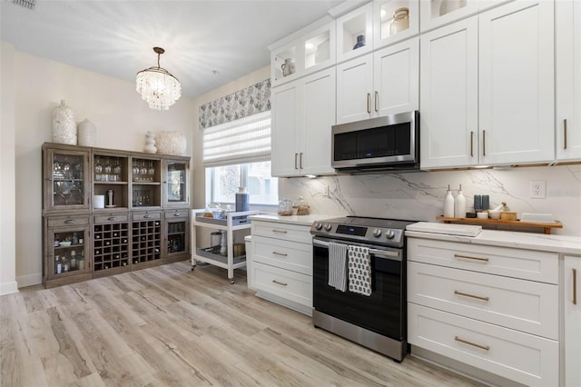 kitchen featuring pendant lighting, stainless steel appliances, and white cabinets