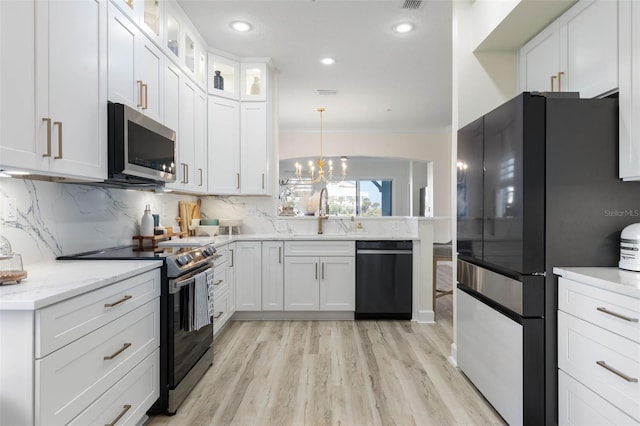 kitchen featuring white cabinets, decorative light fixtures, sink, and black appliances