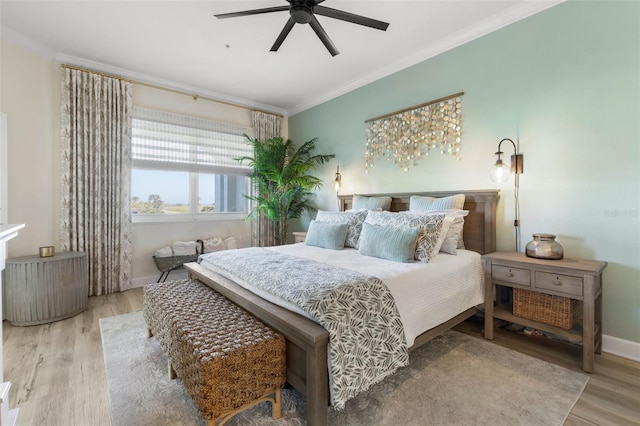 bedroom with ornamental molding, ceiling fan, and light wood-type flooring