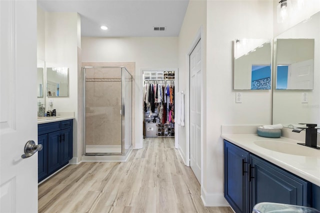 bathroom featuring vanity, a shower with door, and hardwood / wood-style floors