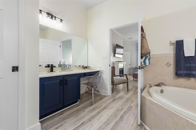 bathroom featuring vanity, hardwood / wood-style flooring, and tiled bath