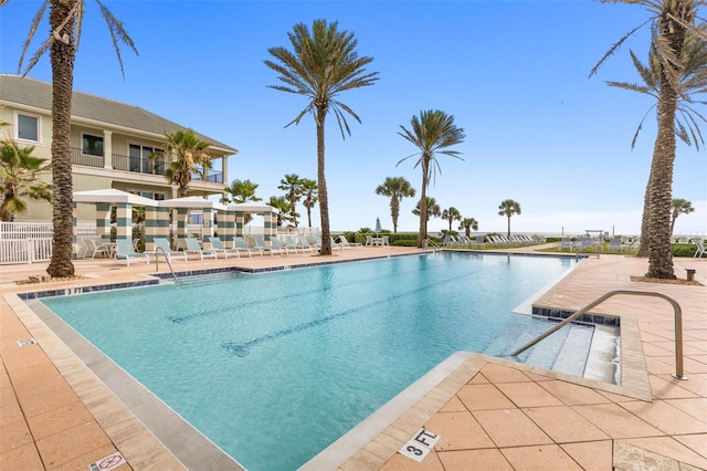 view of swimming pool with a patio and a water view