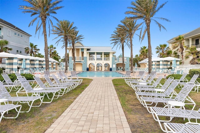 rear view of property featuring a community pool and a patio