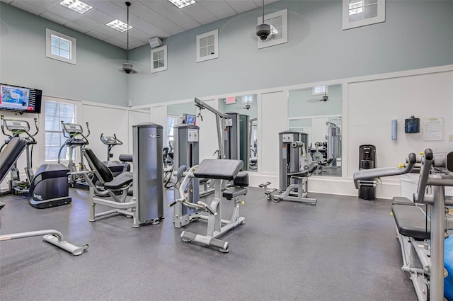 gym featuring a paneled ceiling and a high ceiling