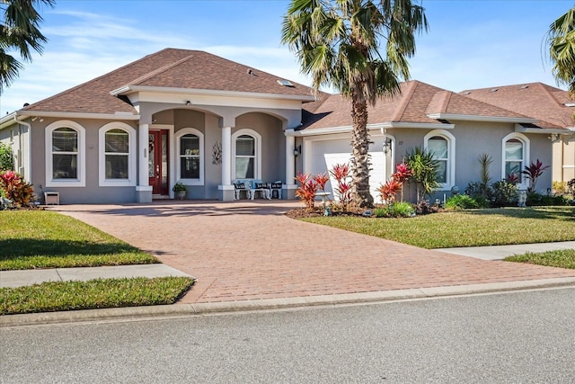 mediterranean / spanish-style home with a garage and a front lawn