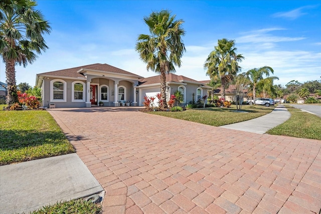 mediterranean / spanish-style home with a porch, a garage, and a front lawn