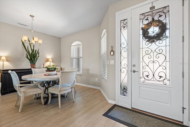 foyer entrance featuring an inviting chandelier and light hardwood / wood-style floors