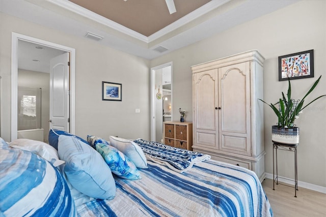 bedroom with a raised ceiling, ornamental molding, ceiling fan, and light hardwood / wood-style flooring