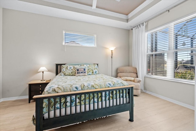 bedroom featuring a raised ceiling, crown molding, and hardwood / wood-style flooring