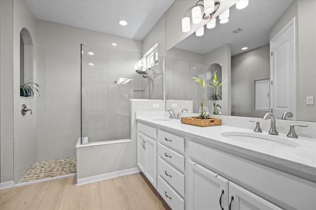 bathroom featuring vanity, hardwood / wood-style floors, and a tile shower