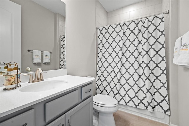 full bathroom with shower / bath combination with curtain, vanity, toilet, and hardwood / wood-style floors