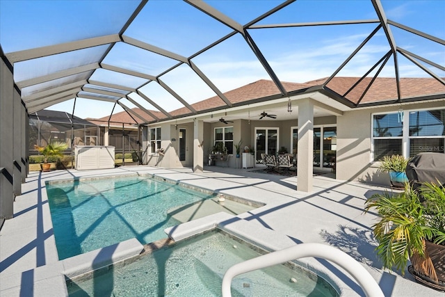 view of swimming pool featuring an in ground hot tub, a patio area, ceiling fan, and glass enclosure