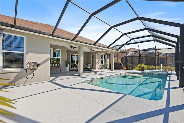 view of pool with a patio, an in ground hot tub, ceiling fan, and glass enclosure